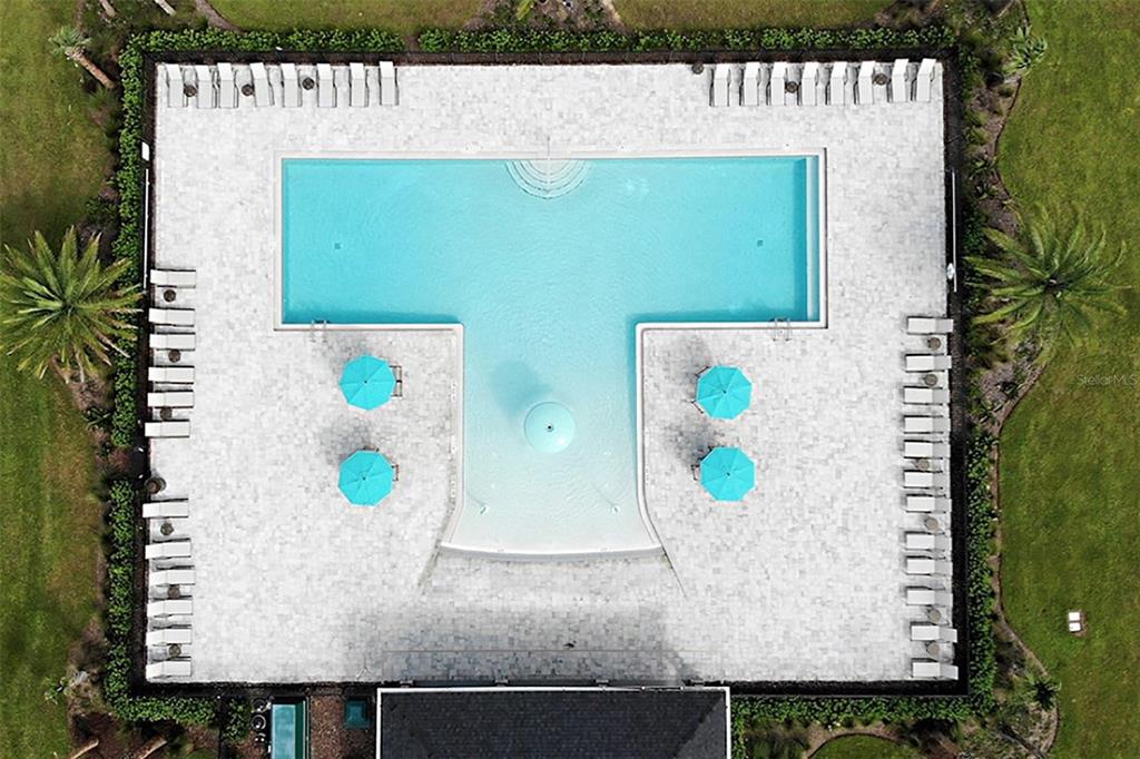 An aerial view shows a T-shaped swimming pool surrounded by lounge chairs and umbrellas — 2078 TOWN PASTURE DRIVE, EUSTIS, FL