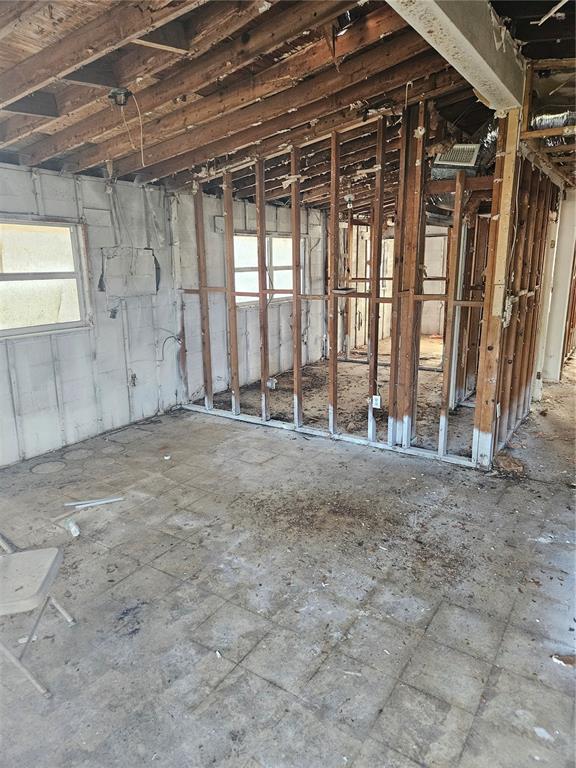 An interior room undergoing renovation with exposed wall studs, ceiling joists, and unfinished flooring — 2814 PALMADELIA AVENUE, SARASOTA, FL