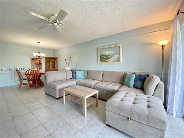 A living room features a large sectional sofa, a coffee table, and a dining area — 608 NE 2nd St # 434, Dania Beach FL 33004, DANIA BEACH, FL