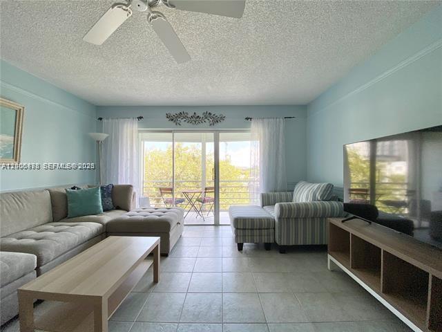 A living room features a sectional sofa, a coffee table, and a television on a stand — 608 NE 2nd St # 434, Dania Beach FL 33004, DANIA BEACH, FL