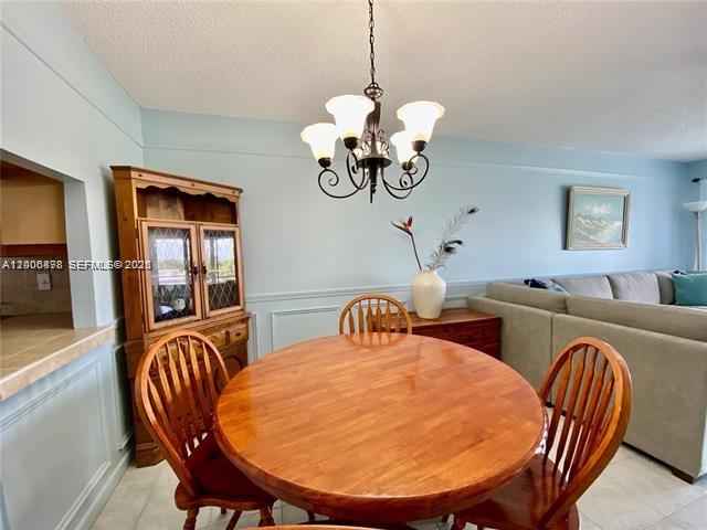 A dining area features a round wooden table, spindle chairs, and a traditional hutch — 608 NE 2nd St # 434, Dania Beach FL 33004, DANIA BEACH, FL