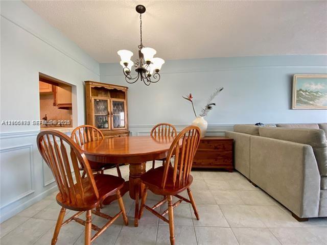 A dining area features a wooden table, four chairs, a hutch, and a chandelier — 608 NE 2nd St # 434, Dania Beach FL 33004, DANIA BEACH, FL