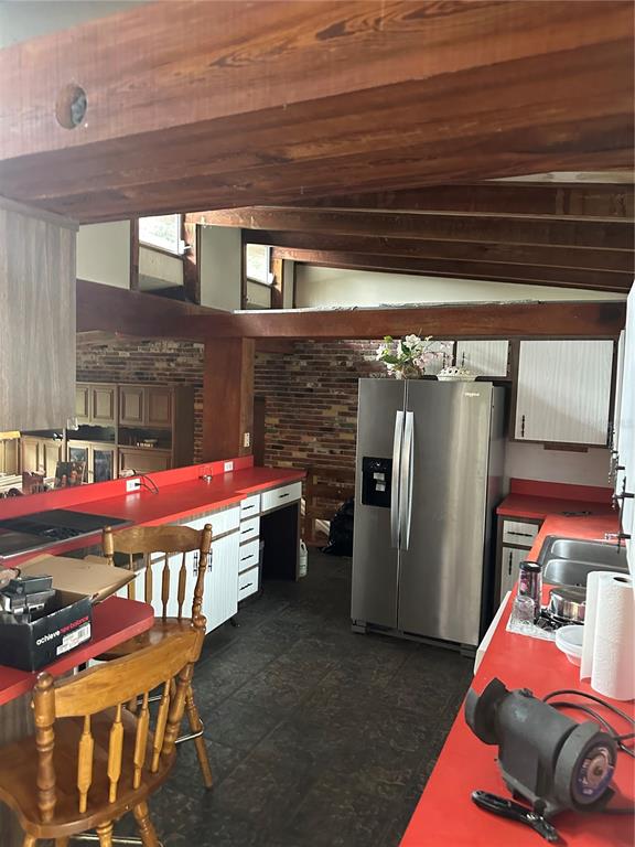 A kitchen features red countertops, exposed wooden beams, and a brick wall — 4998 LAKE LOWERY ROAD, HAINES CITY, FL
