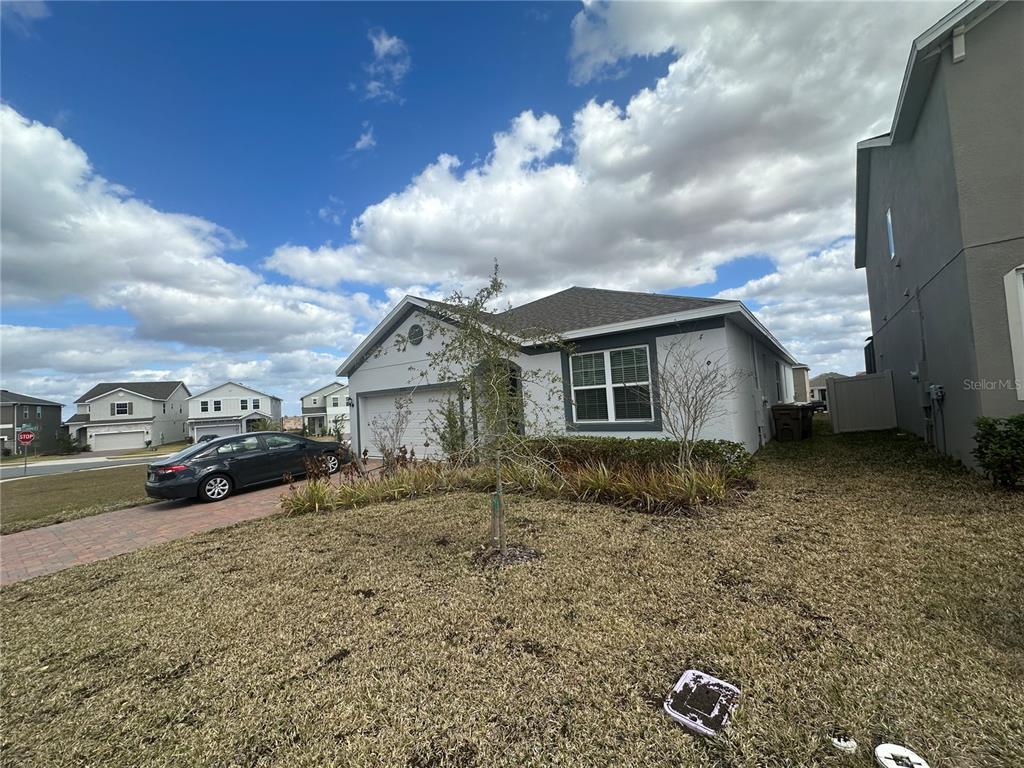 A single-story house with a gray exterior, a two-car garage, and a paved driveway — 7776 MARSALA STREET, CLERMONT, FL