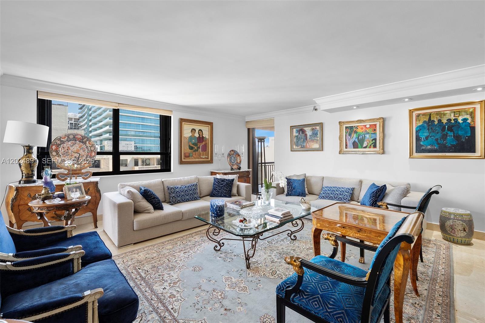 A living room features a large sectional sofa, blue armchairs, and several framed paintings — 10175 Collins Ave # 1505, Bal Harbour FL 33154, BAL HARBOUR, FL