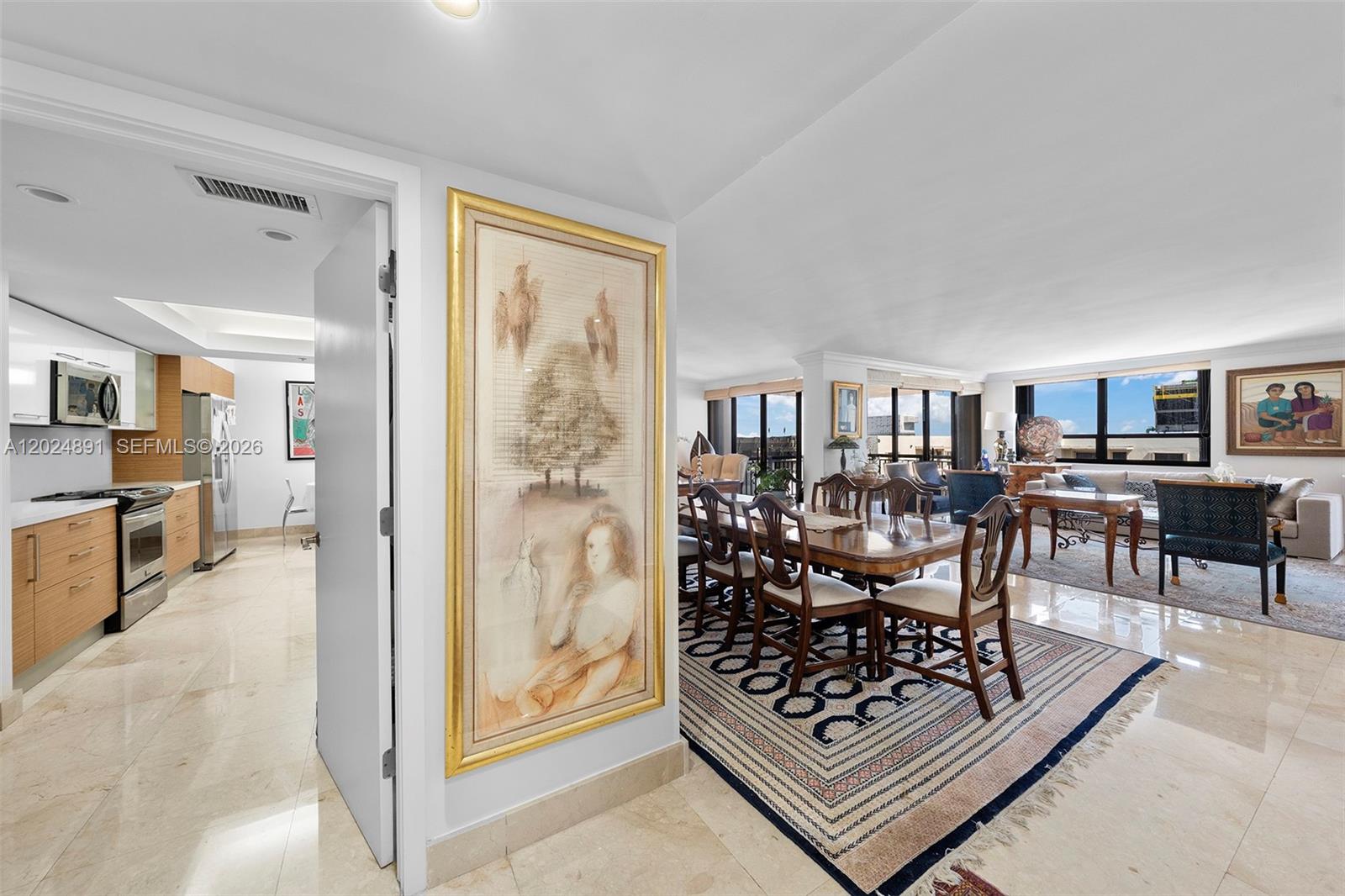 A dining area and living room with tile floors, area rugs, and a nearby kitchen — 10175 Collins Ave # 1505, Bal Harbour FL 33154, BAL HARBOUR, FL