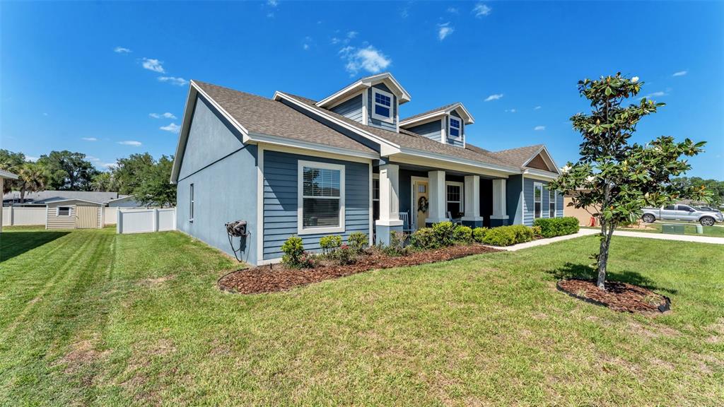 A blue house with a front porch, dormer windows, and a landscaped yard — 254 KISSENGEN PARK DRIVE, BARTOW, FL