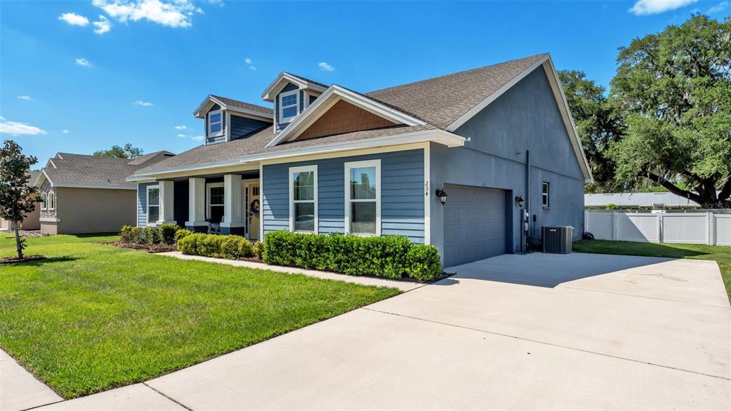A blue house with a two-car garage, dormer windows, and a concrete driveway — 254 KISSENGEN PARK DRIVE, BARTOW, FL