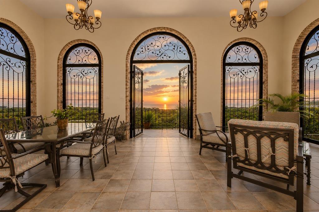 A dining room with arched windows, wrought iron grilles, and a sunset view over water — Carr 100 km 2.7 BO. GUANAJIBO, CABO ROJO, PR