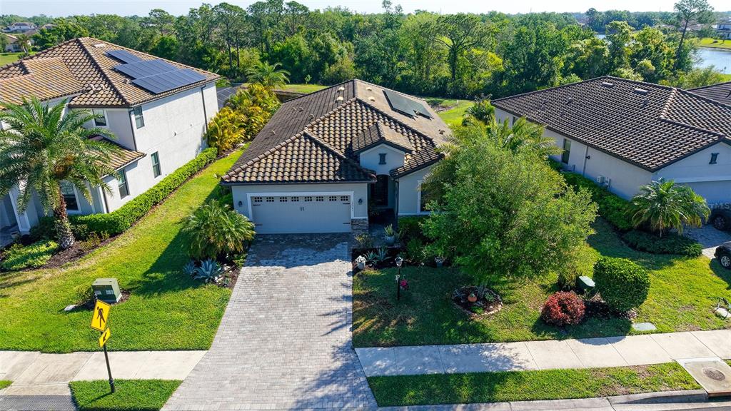 An aerial view shows a single-story house with a tiled roof and a paved driveway — 17241 BLUE RIDGE PLACE, BRADENTON, FL