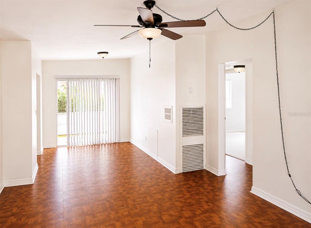 An empty room with wood-patterned flooring, a ceiling fan, and a sliding glass door — 446 NEW YORK AVENUE, DUNEDIN, FL