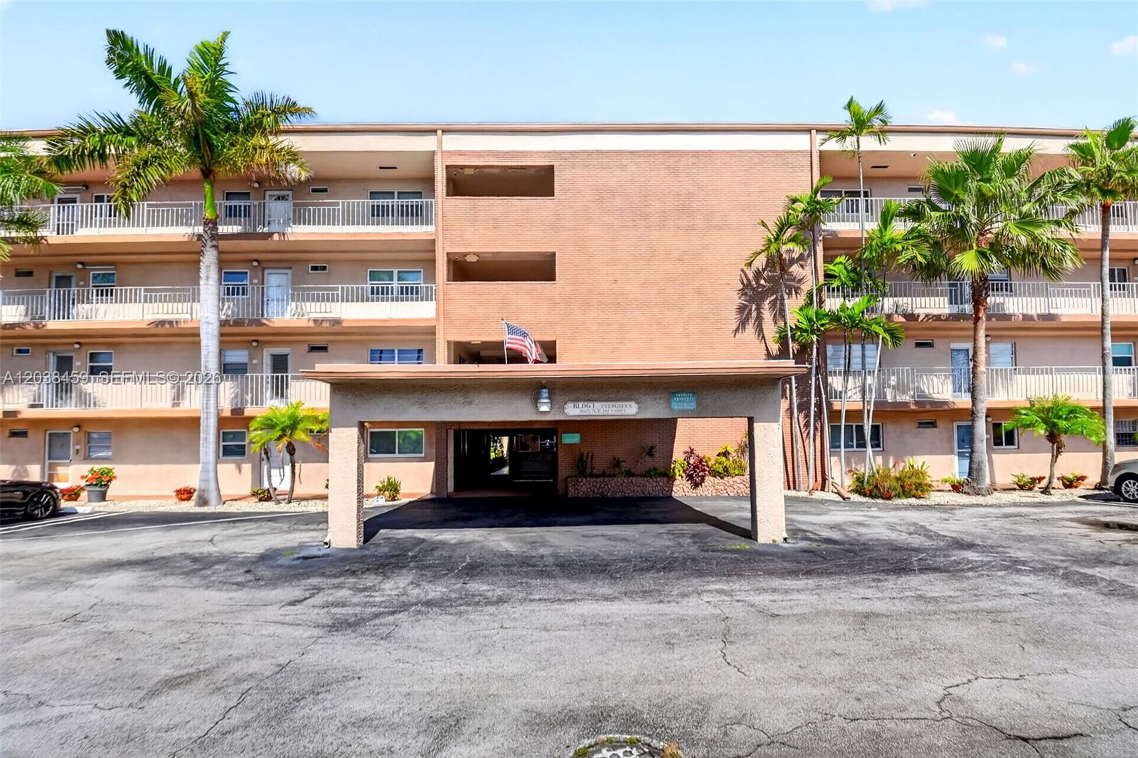 A three-story brick apartment building features a covered entrance and palm trees in front — 2615 NE 1st Ct # 303, Boynton Beach FL 33435, BOYNTON BEACH, FL