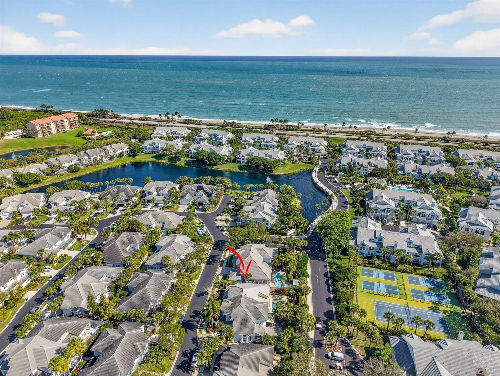 An aerial view shows a residential community with houses, a lake, and tennis courts — 3069 Mainsail Circle, Jupiter FL 33477, JUPITER, FL
