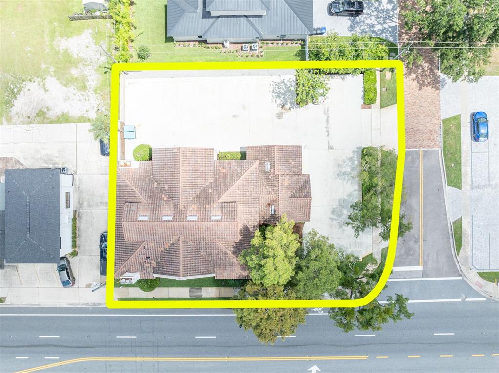 An aerial view shows a house with a tiled roof and a large concrete parking area — 1477 W FAIRBANKS AVENUE, WINTER PARK, FL