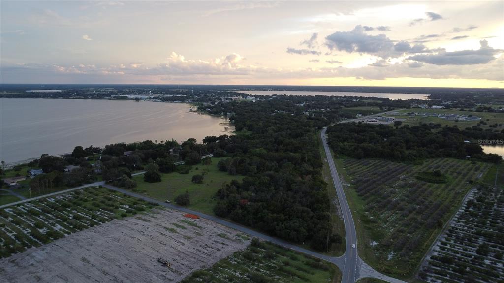 An aerial view shows a road running through rural land next to a large lake — 742 N LAKE REEDY BOULEVARD, FROSTPROOF, FL