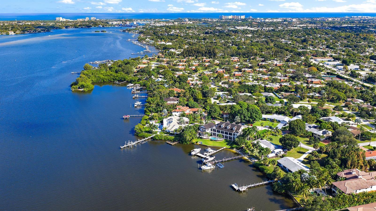 An aerial view of a waterfront residential neighborhood with a large house and private docks — 18137 Palm Point Drive, Jupiter FL 33458, JUPITER, FL