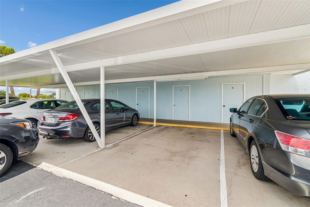 A covered parking area features several numbered doors leading to individual units — 11110 CARRIAGE HILL DRIVE UNIT 5, PORT RICHEY, FL