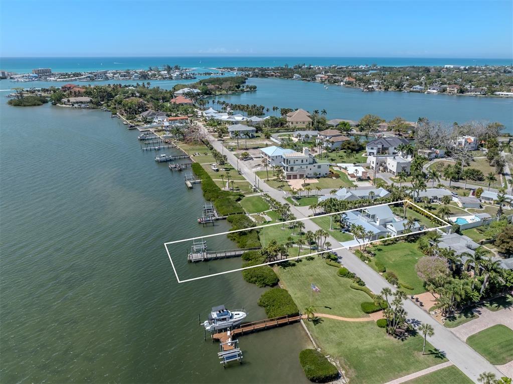 An aerial view shows a waterfront house with a private dock on a grassy lot — 212 SUNRISE DRIVE, NOKOMIS, FL