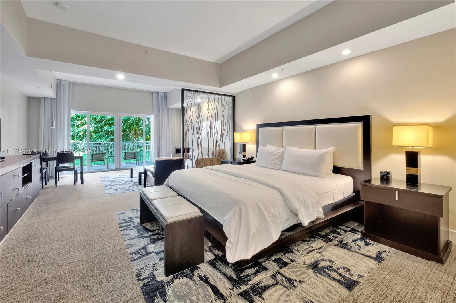 A bedroom features a king bed, a decorative room divider, and a balcony with greenery — 5300 NW 87th Ave # 606, Doral FL 33178, DORAL, FL
