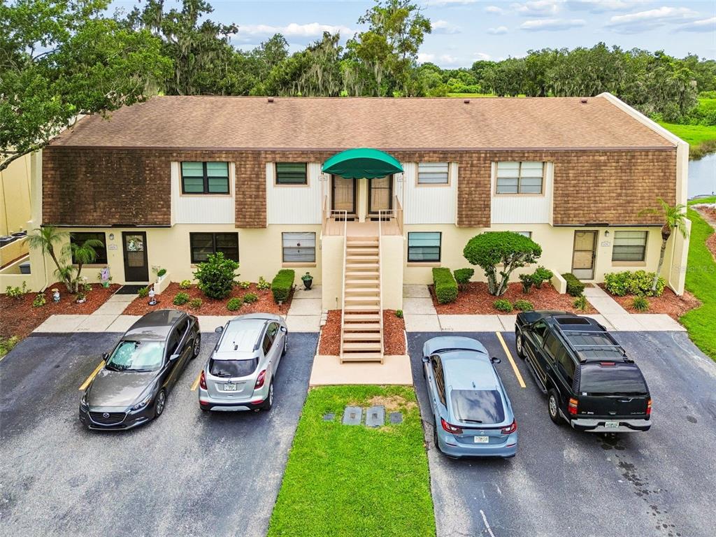 An exterior view of a two-story apartment building with a central staircase and parking lot — 6100 TOPHER TRAIL, MULBERRY, FL