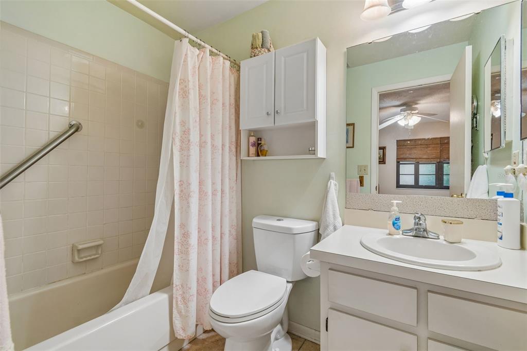 A bathroom features a shower-tub combination, a white toilet, and a vanity with a mirror — 6100 TOPHER TRAIL, MULBERRY, FL