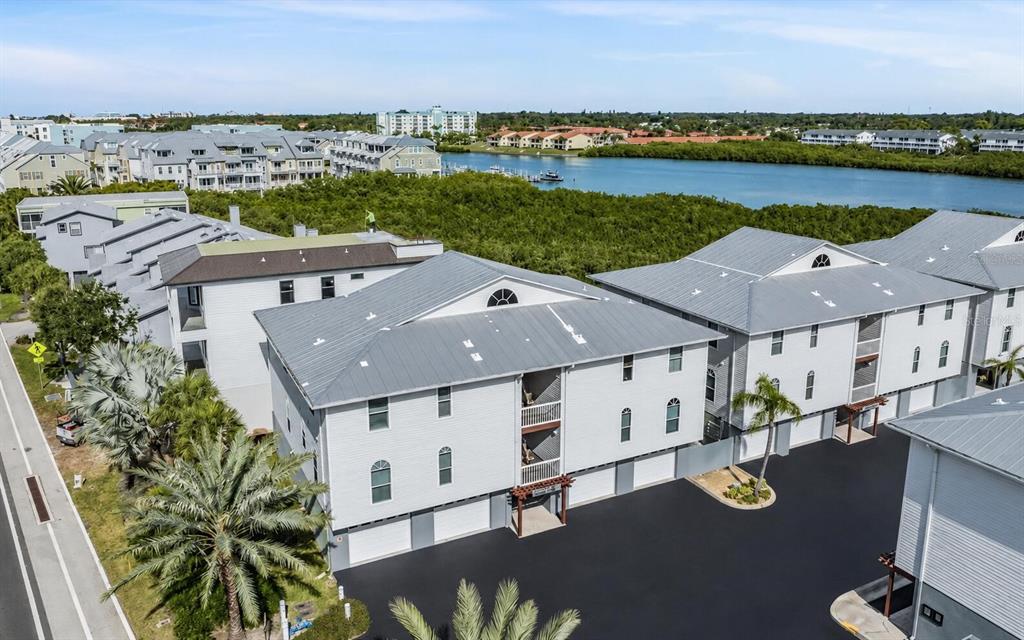 An aerial view shows a swimming pool with lounge chairs, a small building, and parking — 19829 GULF BOULEVARD UNIT 103, INDIAN ROCKS BEACH, FL