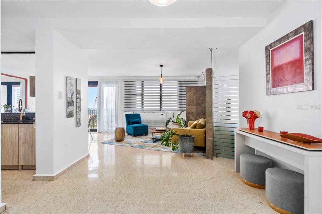 A balcony with two white chairs and a wooden table overlooks a city view — 1202 Av Magdalena MAGDALENA UNIT 702, SAN JUAN, PR