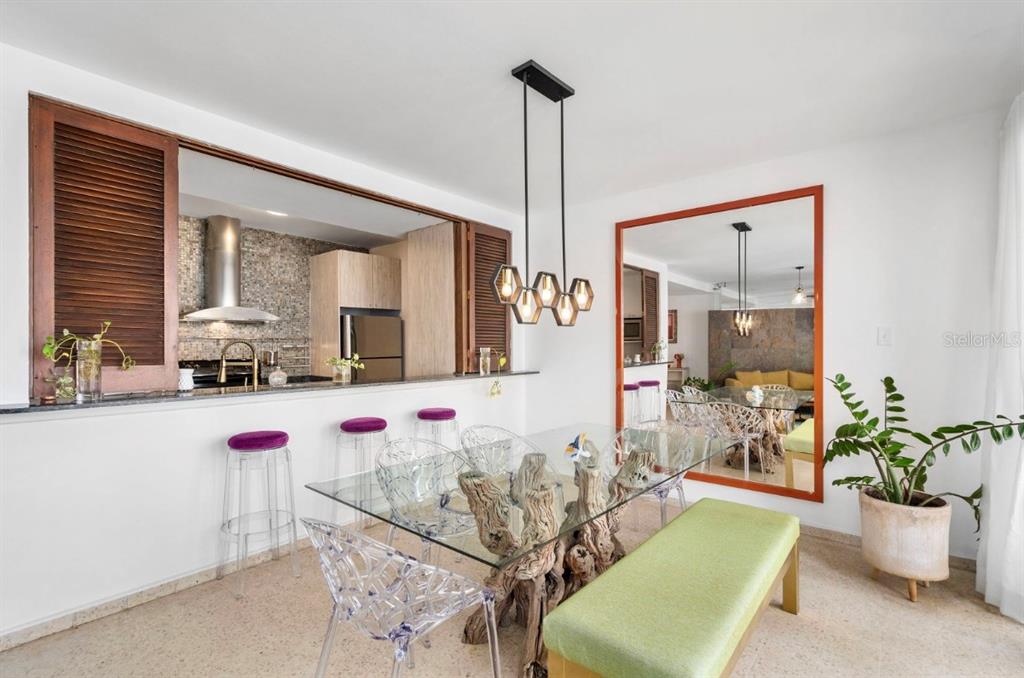 A bright living area features terrazzo floors, a blue armchair, a yellow sofa, and blinds — 1202 Av Magdalena MAGDALENA UNIT 702, SAN JUAN, PR