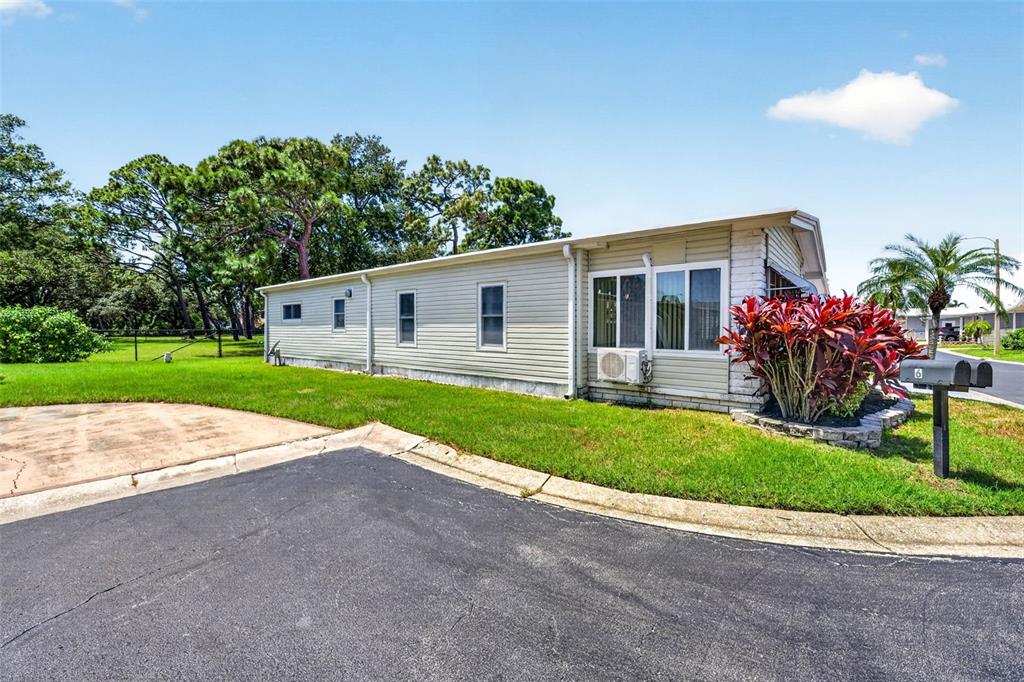 A light-colored mobile home with a side yard, driveway, and a mailbox on a post — 12501 ULMERTON ROAD UNIT 5, LARGO, FL