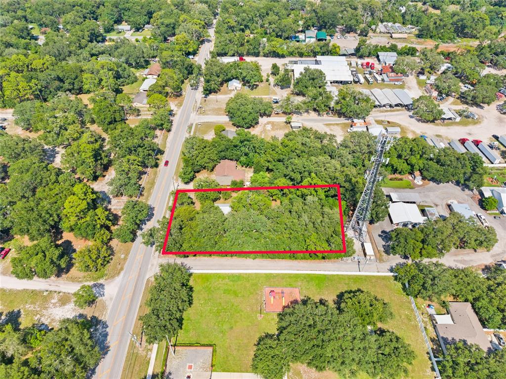 An aerial view shows a rectangular, tree-covered lot outlined in red next to a road — 140 W PONKAN ROAD, APOPKA, FL