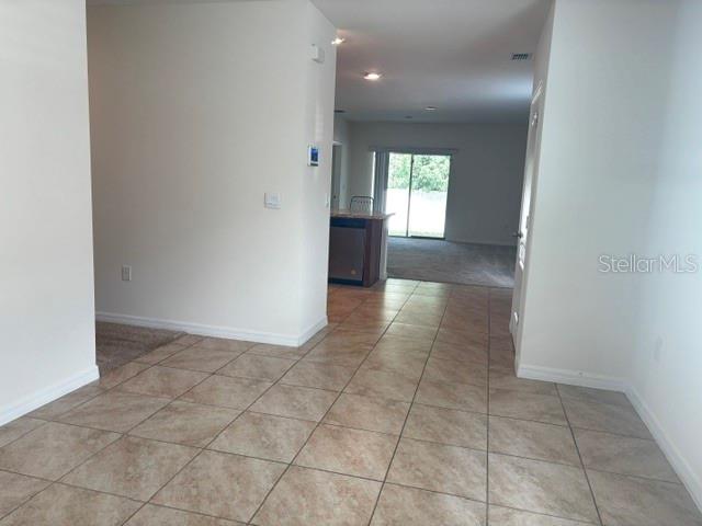 A tiled entryway leads into an open-concept living area with a kitchen and sliding doors — 335 GINA LANE, DAVENPORT, FL