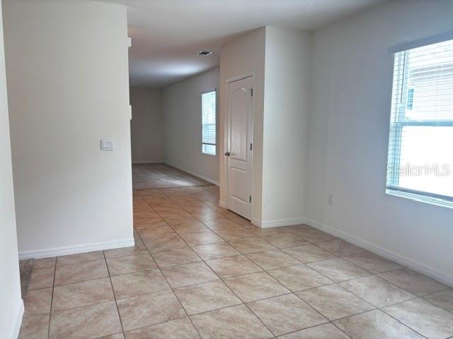An interior view shows a room with tiled floors, a white door, and a window — 335 GINA LANE, DAVENPORT, FL