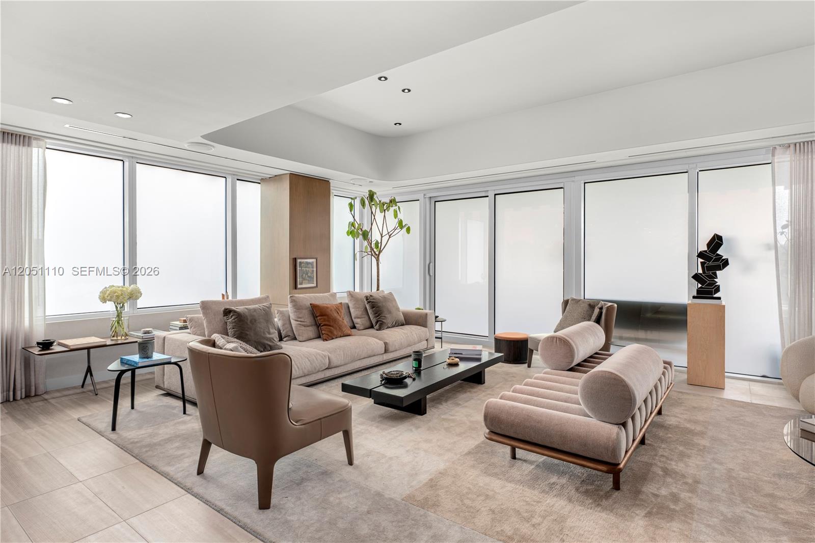 A modern living room features a large beige sofa, a low coffee table, and floor-to-ceiling windows — 4701 N Meridian Ave # 421, Miami Beach FL 33140, MIAMI BEACH, FL