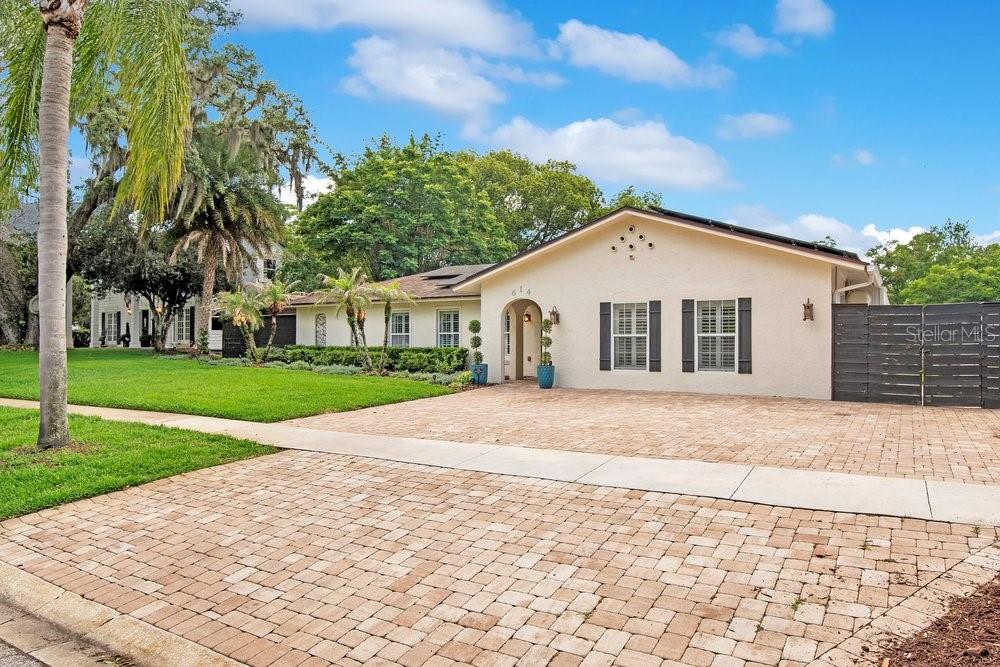 A single-story house with a light-colored stucco exterior and a brick paver driveway — 614 BROOKWOOD LANE, MAITLAND, FL
