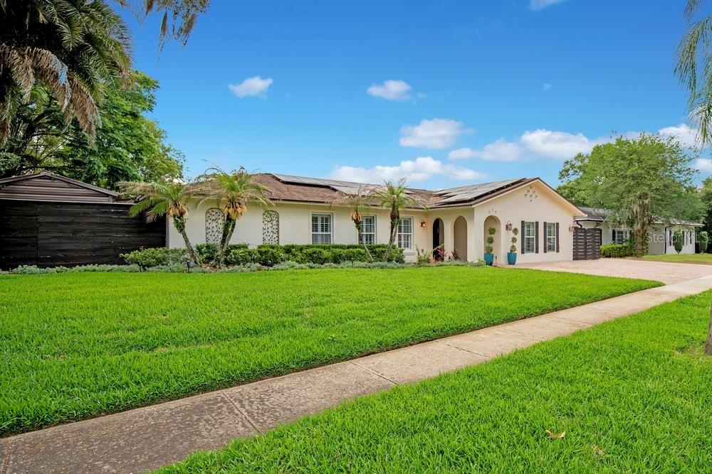 A single-story house with a white exterior, solar panels, and a large front lawn — 614 BROOKWOOD LANE, MAITLAND, FL