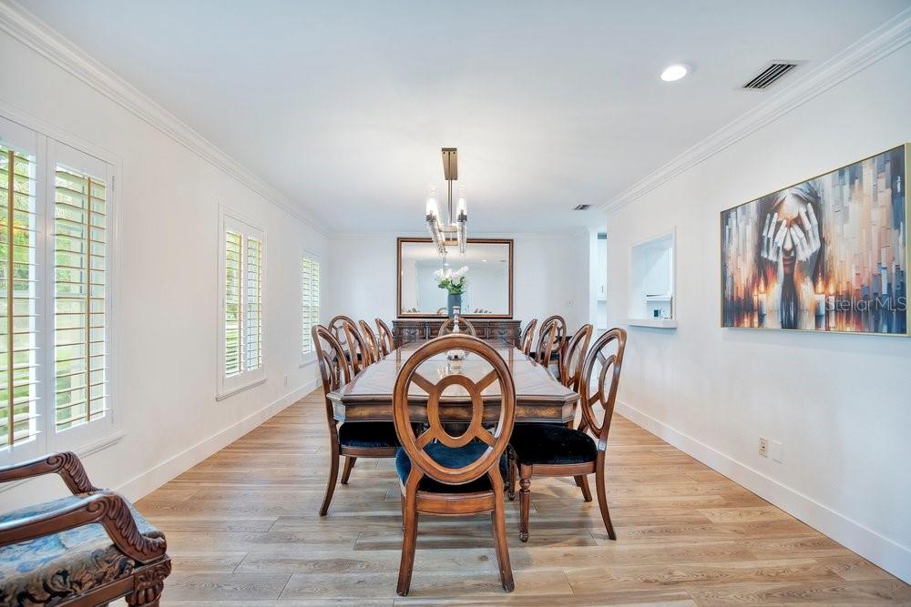 A formal dining room features a long wooden table, eight chairs, and a large wall painting — 614 BROOKWOOD LANE, MAITLAND, FL