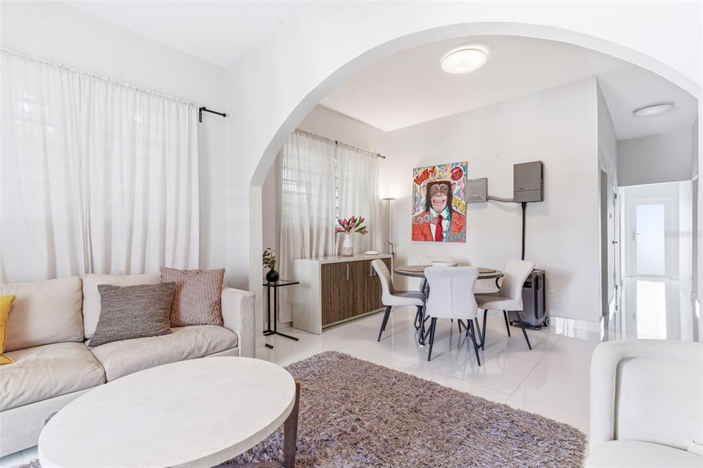 A living room and dining area feature white tile floors, an arched wall, and modern furniture — 56 CALLE F KRUG CONDADO UNIT 6, SAN JUAN, PR