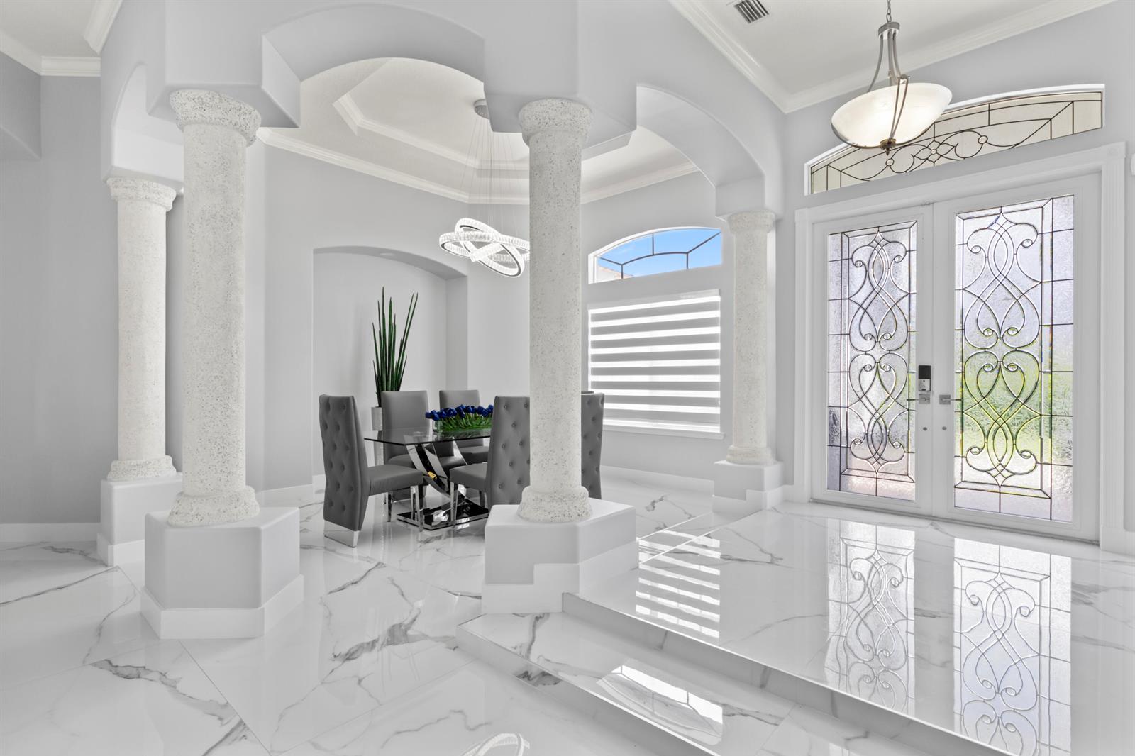 A bright dining area features marble floors, decorative columns, and a glass-topped table — 15062 N 73rd St Street N, FL 33470, FL