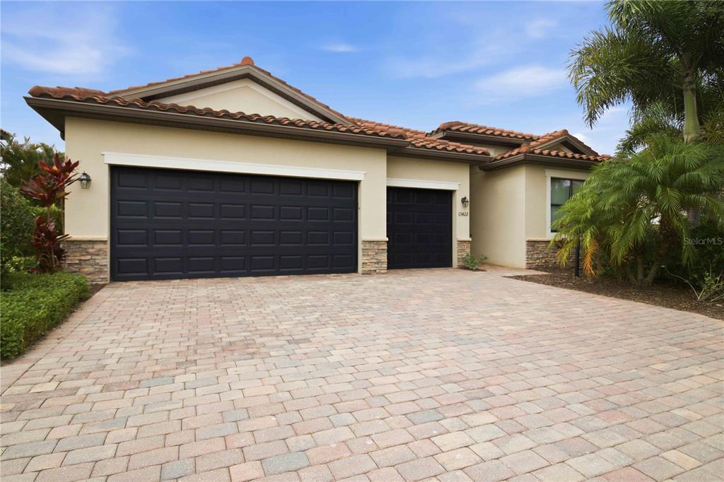A single-story house with a three-car garage and a paved driveway — 13422 SAW PALM CREEK TRAIL, LAKEWOOD RANCH, FL