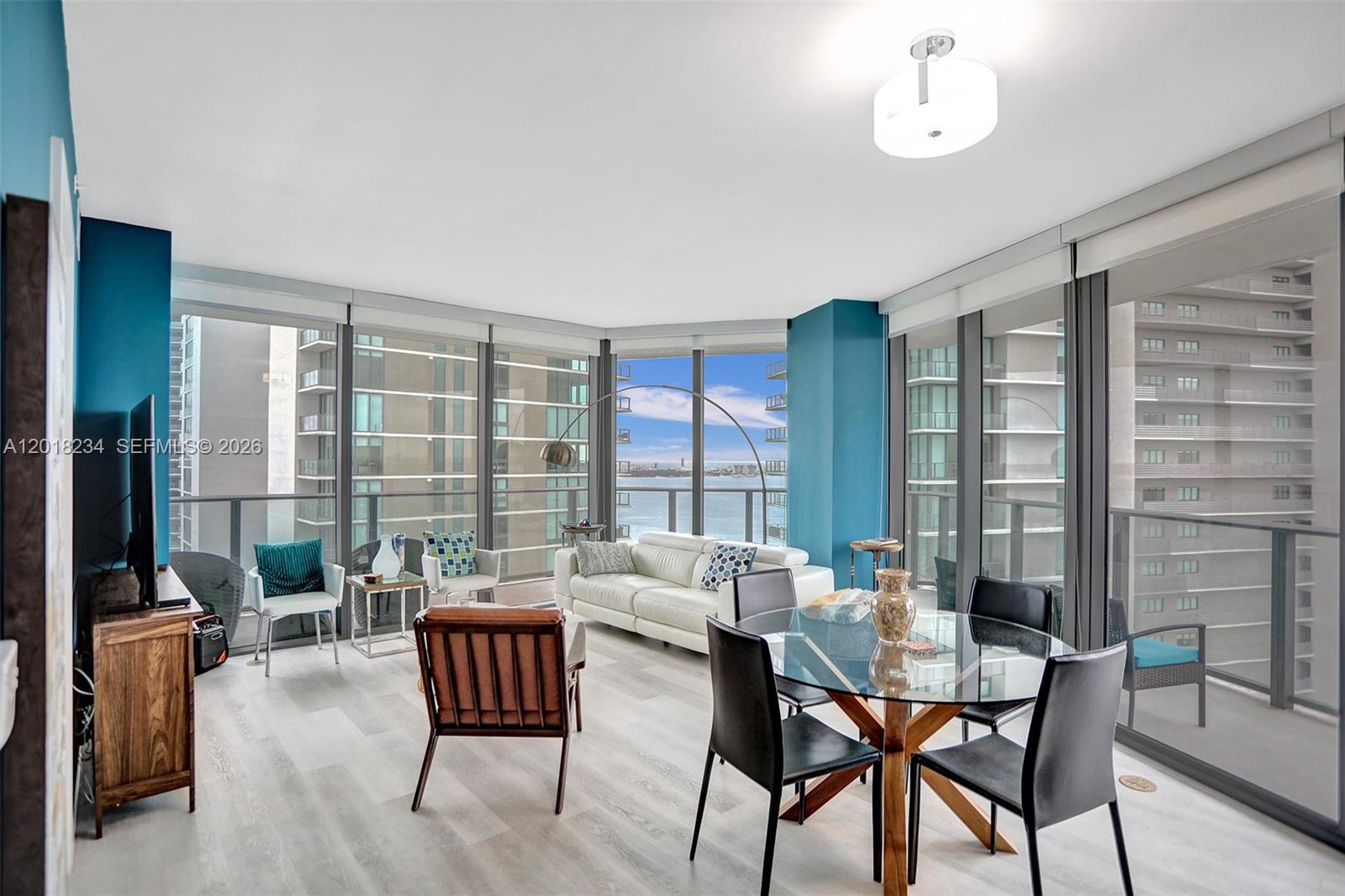 A living and dining area features floor-to-ceiling windows with water views and wood-look flooring — 501 NE 31st St # 3706, Miami FL 33137, MIAMI, FL