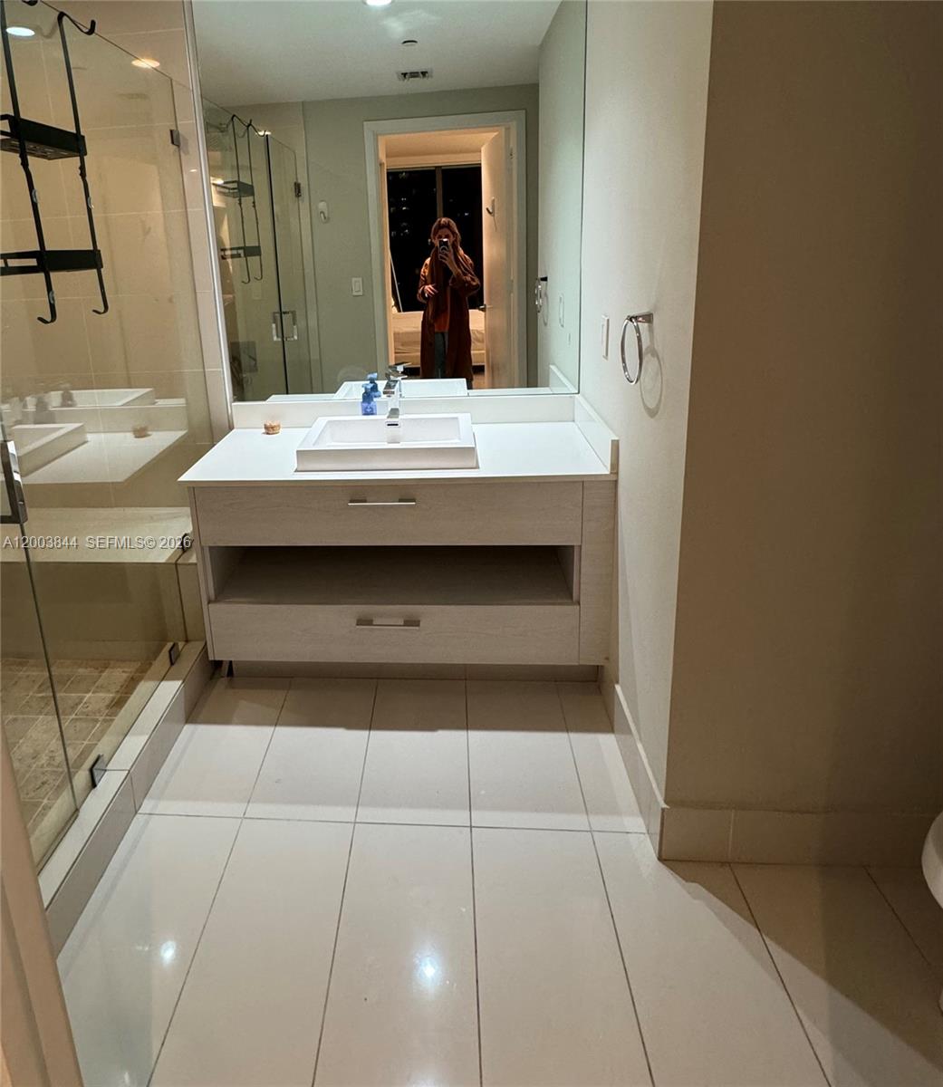 A modern bathroom features a white vanity with a vessel sink and a large mirror — 55 SW 9th St # 1204, Miami FL 33130, MIAMI, FL