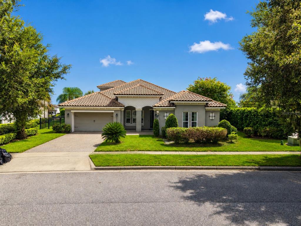 A single-story house with a tiled roof, gray stucco exterior, and a two-car garage — 7573 GREEN MOUNTAIN WAY, WINTER GARDEN, FL