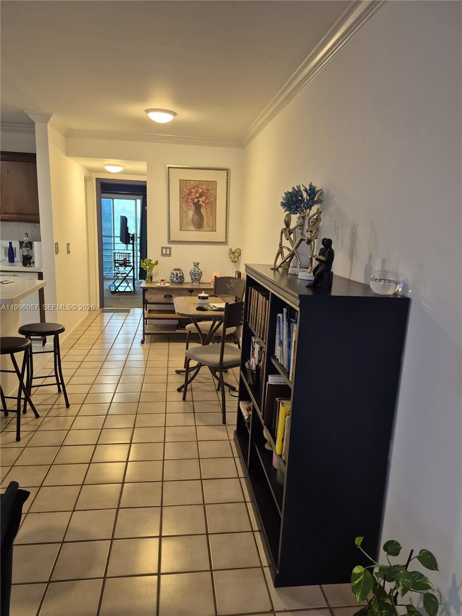 A tiled dining area features a black bookshelf, a small table, and a balcony view — 371 brighton I # 371, Boca Raton FL 33434, BOCA RATON, FL