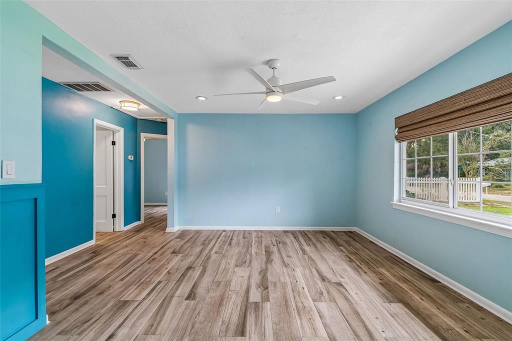 An empty room with light blue walls, wood-look flooring, a ceiling fan, and a window — 1304 E KNOLLWOOD STREET, TAMPA, FL