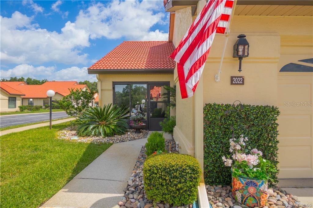 A concrete walkway leads to the front entrance of a house with a tiled roof — 2022 FOREST DRIVE, INVERNESS, FL