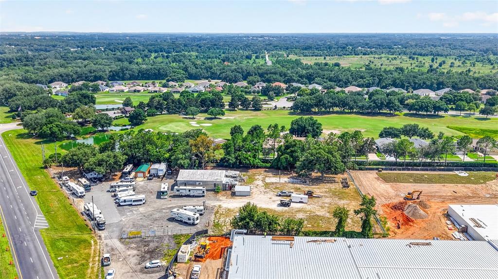 An aerial view shows a commercial lot with RVs, a warehouse, and adjacent residential areas — 27101 US HIGHWAY 27, LEESBURG, FL