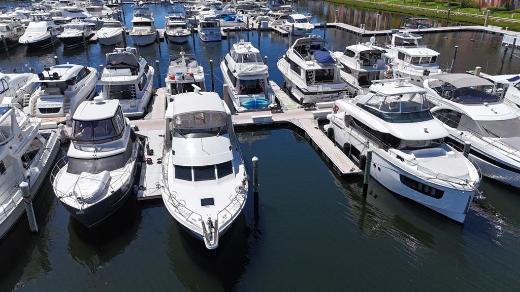 An aerial view shows several white yachts docked in a marina on a sunny day — 102 RIVIERA DUNES WAY UNIT C-7, PALMETTO, FL