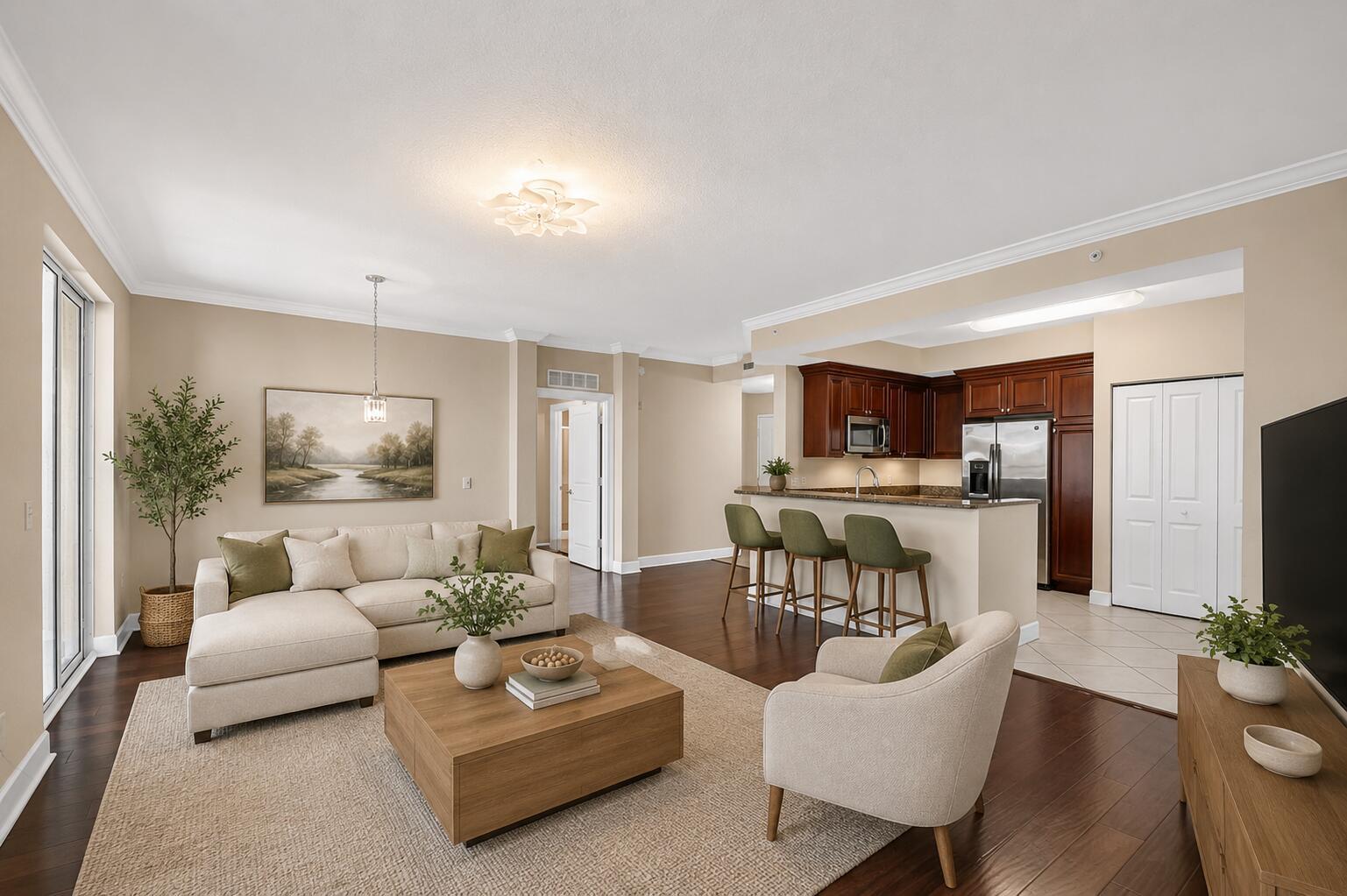 An open-concept living room and kitchen featuring hardwood floors, a sectional sofa, and bar seating — 1660 Renaissance Commons Boulevard # 2517, Boynton Beach FL 33426, BOYNTON BEACH, FL