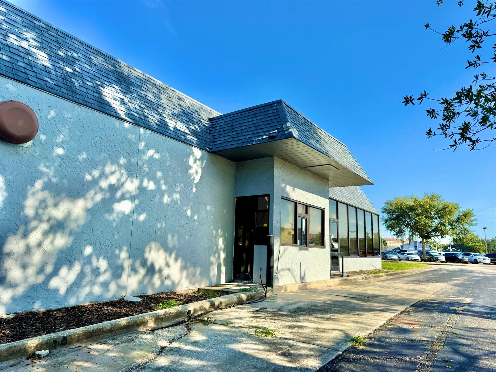 The exterior of a commercial building features a drive-thru window and a dark shingled roof — 1520 Lakeview Drive, Sebring FL 33870, SEBRING, FL