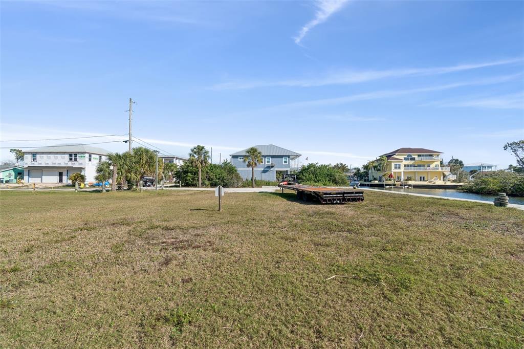 A vacant grassy lot sits in front of several houses near a canal — 6374 BOATYARD DRIVE, HUDSON, FL